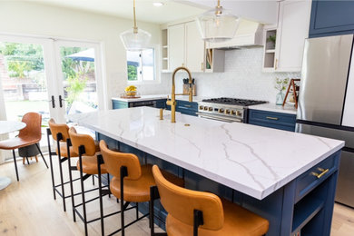 Mid-sized minimalist kitchen photo in San Francisco with a farmhouse sink, shaker cabinets, blue cabinets, white backsplash, mosaic tile backsplash, stainless steel appliances and an island