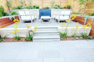 Inspiration for a mid-sized contemporary drought-tolerant and full sun backyard stone and wood fence retaining wall landscape in San Francisco for summer.