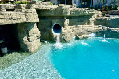Large minimalist backyard tile and custom-shaped natural water slide photo in Other