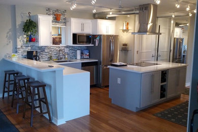 Eat-in kitchen - huge transitional l-shaped bamboo floor eat-in kitchen idea in Minneapolis with an undermount sink, shaker cabinets, white cabinets, quartzite countertops, multicolored backsplash, glass tile backsplash, stainless steel appliances and two islands