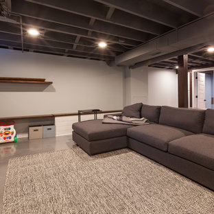 シカゴの中サイズのモダンスタイルのおしゃれな地下室 (半地下 (窓あり) 、グレーの壁、コンクリートの床、暖炉なし、青い床) の写真