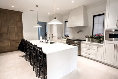 Large minimalist terra-cotta tile and white floor kitchen photo in New York with an undermount sink, shaker cabinets, white cabinets, quartzite countertops, white backsplash, marble backsplash, stainless steel appliances, an island and white countertops