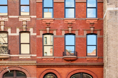 Inspiration for a small brick house exterior in New York with four floors.