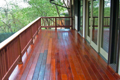 Large elegant wood railing balcony photo in Denver with a roof extension