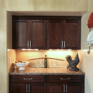 Idées déco pour une grande arrière-cuisine classique avec un évier encastré, un placard à porte persienne, des portes de placard en bois sombre, un plan de travail en granite, une crédence beige, une crédence en carrelage de pierre, un électroménager en acier inoxydable, béton au sol et un îlot central.