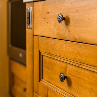 Bild på ett mellanstort amerikanskt beige beige kök, med en undermonterad diskho, luckor med infälld panel, skåp i mellenmörkt trä, bänkskiva i kvarts, flerfärgad stänkskydd, stänkskydd i porslinskakel, rostfria vitvaror, tegelgolv, en halv köksö och rött golv