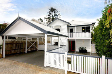 Photo of a mid-sized traditional two-storey white house exterior in Brisbane with wood siding, a gable roof and a metal roof.