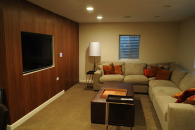 Inspiration for a mid-sized traditional home theatre in Chicago with beige walls, carpet, a wall-mounted tv and brown floor.