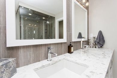 Photo of a mid-sized transitional master bathroom in Calgary with flat-panel cabinets, white cabinets, a freestanding tub, a curbless shower, a two-piece toilet, gray tile, porcelain tile, grey walls, porcelain floors, an undermount sink and quartzite benchtops.