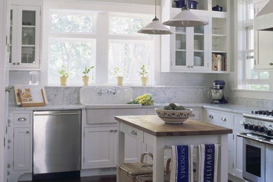 Inspiration for a timeless kitchen remodel in New York with glass-front cabinets, stainless steel appliances and a farmhouse sink