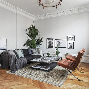 Modelo de salón para visitas abierto, nórdico, grande, sin chimenea y televisor, con paredes grises y suelo de madera en tonos medios