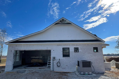 Example of a mid-sized minimalist white one-story vinyl and board and batten exterior home design in Other with a shingle roof and a black roof