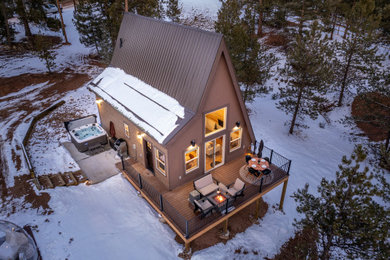 Small modern brown two-story wood exterior home idea in Denver with a metal roof and a gray roof