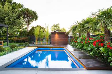 Photo of a tropical backyard rectangular lap pool in Christchurch with decking.