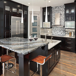 Design ideas for a large contemporary u-shaped kitchen pantry in Calgary with metallic splashback, stainless steel appliances, light hardwood floors, with island, an undermount sink, shaker cabinets, black cabinets and metal splashback.