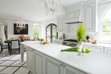 Kitchen - small traditional marble floor kitchen idea in Dallas with an undermount sink, recessed-panel cabinets, white cabinets, marble countertops, white backsplash, stone slab backsplash, paneled appliances and an island