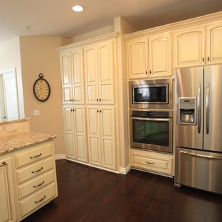 Large kitchen pantry ideas - Example of a large dark wood floor kitchen pantry design in Oklahoma City with recessed-panel cabinets, white cabinets, granite countertops, stainless steel appliances and an island
