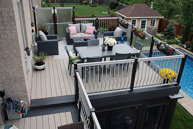 Design ideas for a large modern backyard deck in Toronto with a fire feature.