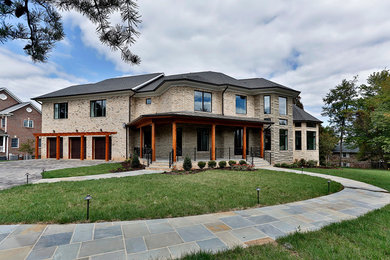 Large elegant beige two-story brick exterior home photo in DC Metro