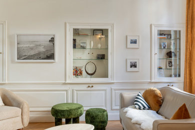 Cette photo montre un salon tendance avec un mur blanc, un sol en bois brun, un sol marron et boiseries.