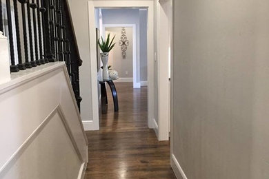 Hallway - mid-sized traditional medium tone wood floor hallway idea in Austin with gray walls