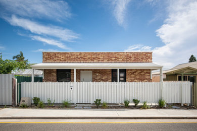 Ispirazione per la micro casa contemporanea a un piano con rivestimento in mattoni e tetto bianco