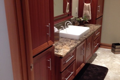 Bathroom - mid-sized contemporary 3/4 beige tile bathroom idea in Grand Rapids with recessed-panel cabinets, medium tone wood cabinets, beige walls, a pedestal sink and granite countertops