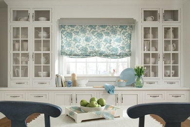 Example of a mid-sized cottage galley eat-in kitchen design in Orange County with shaker cabinets, white cabinets and solid surface countertops