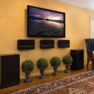 Inspiration for a medium sized classic enclosed home cinema in Other with yellow walls, dark hardwood flooring, a wall mounted tv and brown floors.