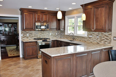 Eat-in kitchen - large transitional u-shaped beige floor eat-in kitchen idea in Philadelphia with dark wood cabinets, multicolored backsplash, stainless steel appliances, a peninsula, an undermount sink and raised-panel cabinets