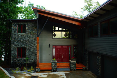 Example of a large minimalist gray three-story mixed siding exterior home design in New York with a shed roof