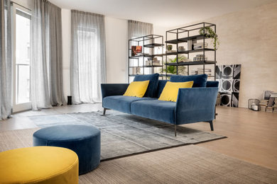 Esempio di un grande soggiorno minimalista aperto con libreria, pareti beige e parquet chiaro