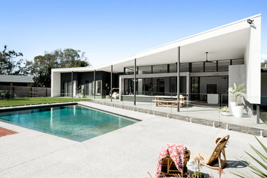 Imagen de fachada de casa blanca y blanca minimalista con revestimiento de aglomerado de cemento