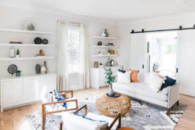 Example of a mid-sized beach style open concept light wood floor and beige floor living room design in New York with white walls and no fireplace