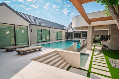 Example of a large courtyard stone and rectangular infinity and privacy pool design in Houston