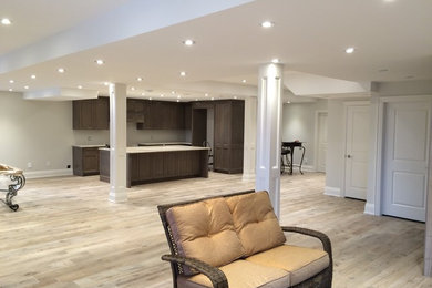 Inspiration for a large transitional underground light wood floor and beige floor basement remodel in Toronto with gray walls