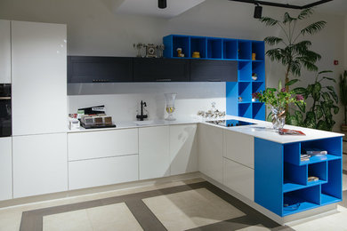 На фото: угловая кухня в современном стиле с монолитной мойкой, столешницей из акрилового камня, белым фартуком и полом из керамогранита с