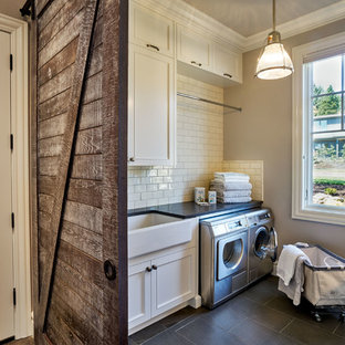 Foto de cuarto de lavado en U, clásico, grande, con fregadero sobremueble, armarios con paneles empotrados, puertas de armario blancas, encimera de cuarzo compacto, paredes beige, suelo de baldosas de porcelana y lavadora y secadora juntas