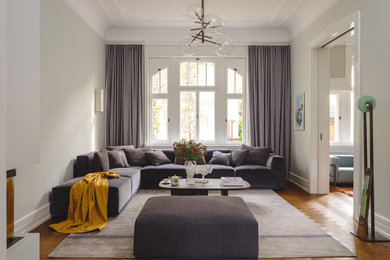 Großes, Offenes Klassisches Wohnzimmer mit braunem Holzboden, Kaminofen, Kaminumrandung aus Metall und TV-Wand in Frankfurt am Main