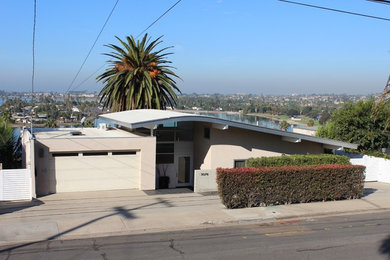 Inspiration for a small contemporary beige two-story stucco house exterior remodel in San Diego with a shed roof and a shingle roof