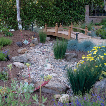 Dry creek (stormwater retention) and wooden bridge connecting DG pathway