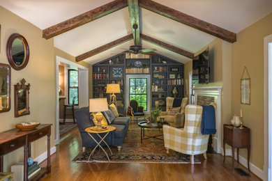 Photo of a mid-sized traditional enclosed family room in St Louis with beige walls, medium hardwood floors, a standard fireplace, a stone fireplace surround, brown floor, exposed beam and vaulted.