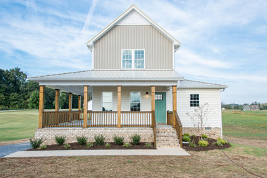 Diseño de fachada de casa beige campestre de tamaño medio de dos plantas con revestimiento de vinilo y tejado de metal