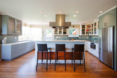 Kitchen - mid-sized contemporary u-shaped medium tone wood floor kitchen idea in Seattle with an undermount sink, white cabinets, marble countertops, gray backsplash, glass tile backsplash, stainless steel appliances and an island