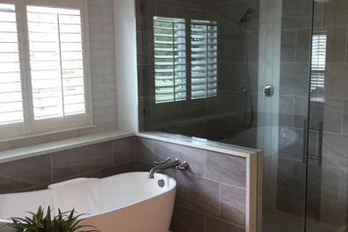 This is an example of a medium sized modern ensuite bathroom in Austin with grey cabinets, a corner shower, grey tiles, multi-coloured walls, a submerged sink, marble worktops, grey floors, a hinged door and multi-coloured worktops.