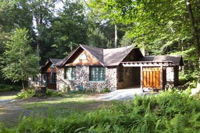 Mid-sized arts and crafts beige one-story stone gable roof photo in Philadelphia