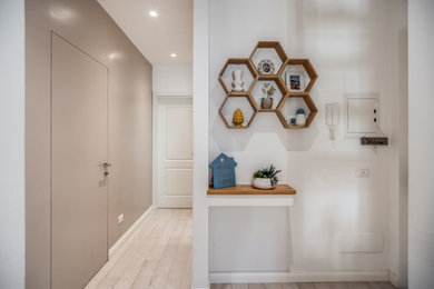 Idee per un piccolo ingresso minimalista con pareti beige e parquet chiaro