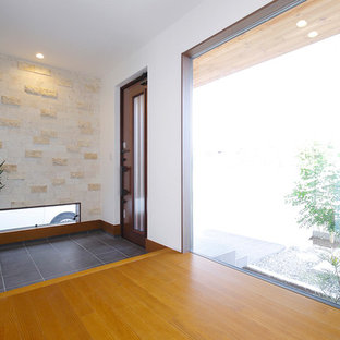 他の地域の片開きドアモダンスタイルのおしゃれな玄関 (白い壁、淡色木目調のドア) の写真