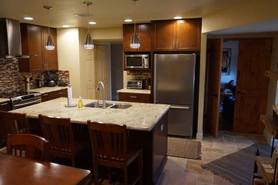Inspiration for a mid-sized contemporary galley travertine floor eat-in kitchen remodel in Phoenix with an undermount sink, shaker cabinets, medium tone wood cabinets, granite countertops, multicolored backsplash, mosaic tile backsplash, stainless steel appliances and an island
