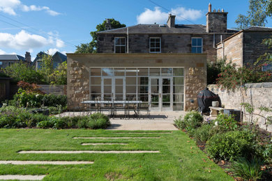 Inspiration for a mid-sized timeless one-story stone exterior home remodel in Edinburgh with a green roof